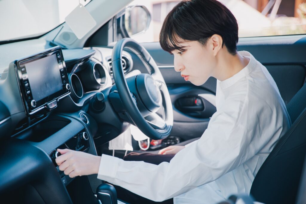 車のエアコンを操作するママ