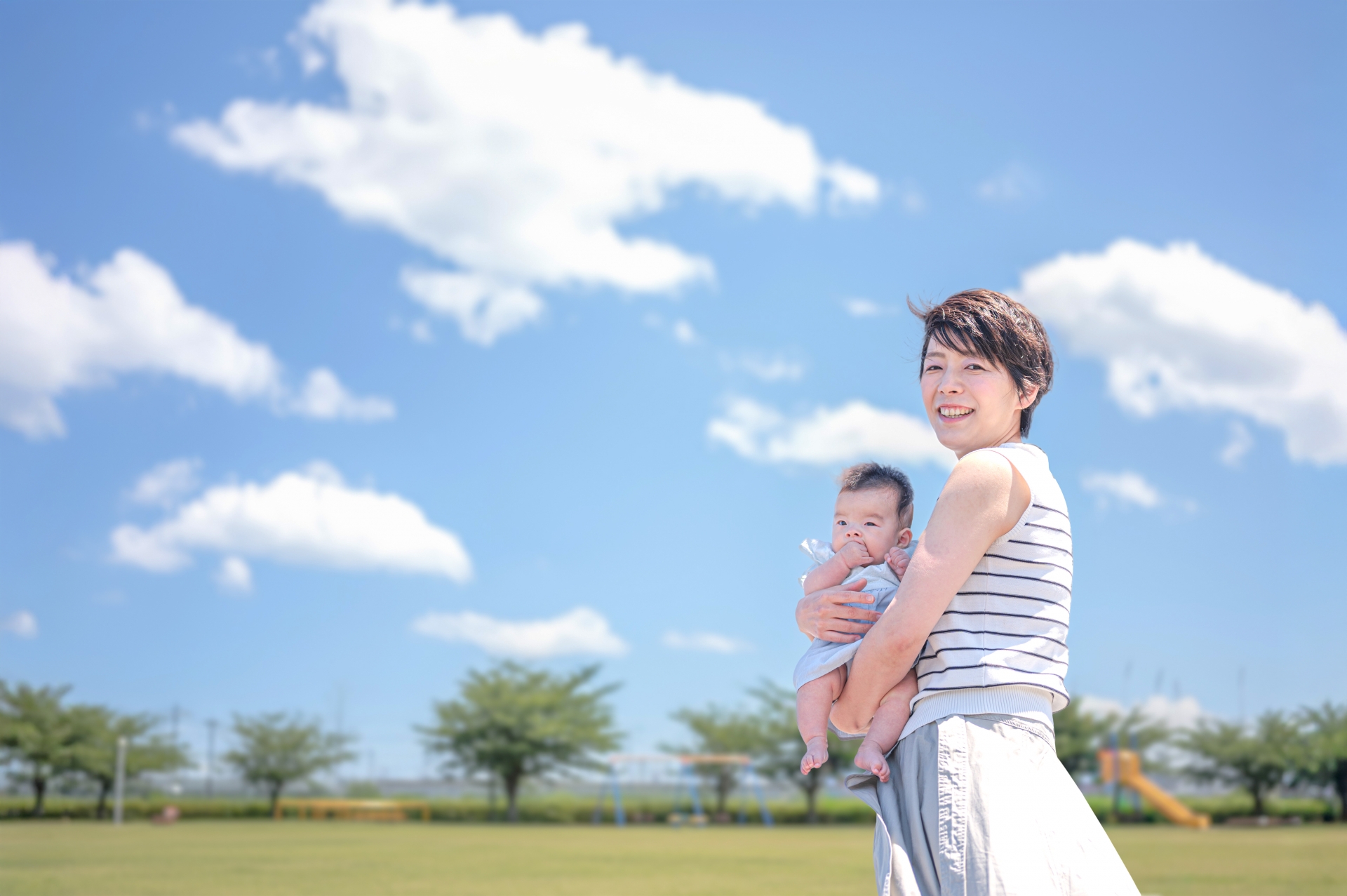 青空が広がる公園にいる親子